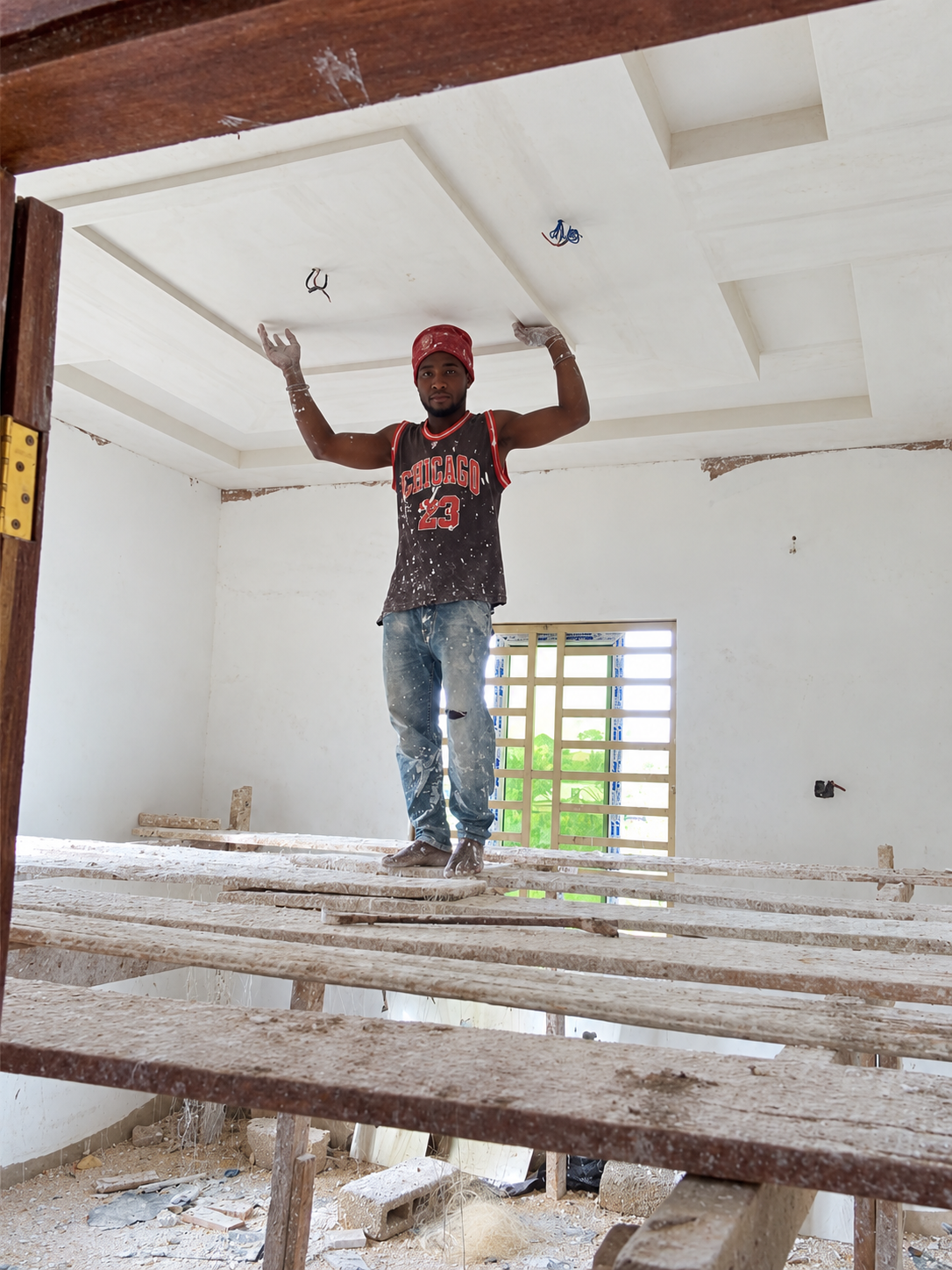 Worker on scaffolding beneath a POP ceiling under construction