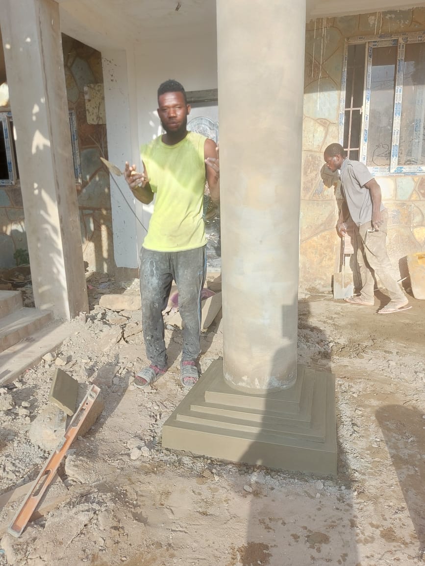 Worker beside column base moulding — masonry and construction work by Mr. Aziz Adbul