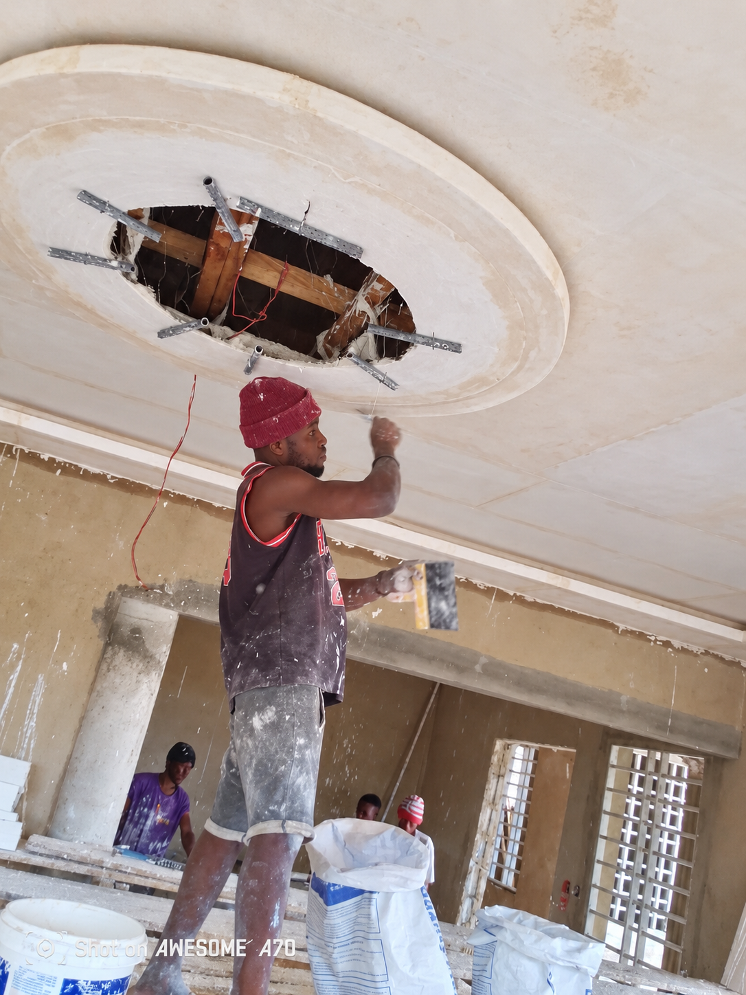 Circular POP ceiling feature being repaired