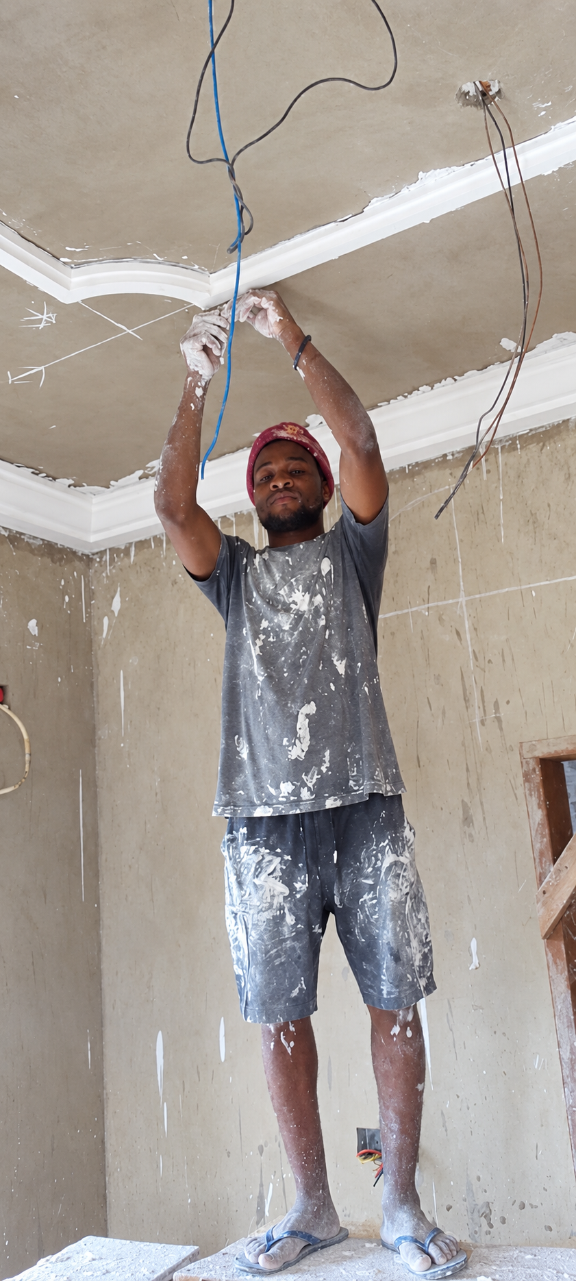 Mr. Felix fitting decorative cornice moulding on a ceiling